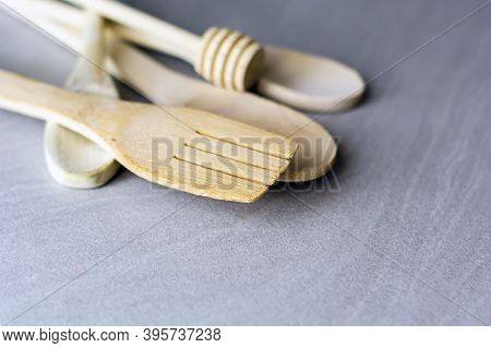 Group Of Wooden Kitchen Utensils Arranged On A Gray Marble Table. Selective Focus On The Carving For
