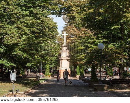 Pancevo, Serbia - September 26, 2020: People Passing By The Calvary And Catholic Cross Of The Trg Kr