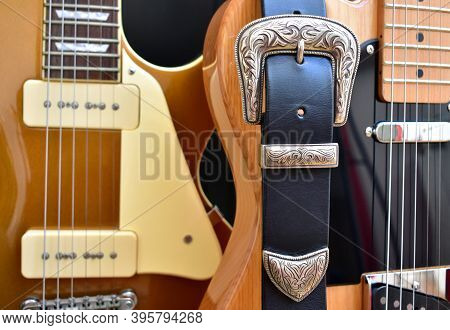 Electric Guitars And Leather Strap With Silver Buckle Close-up.