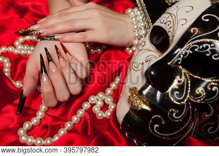 Fashionable Stilettos Nails Design With Venetian Buffoon Mask, Beads On Red Silk