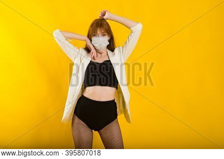 Female Strip Dancer In Yellow Studio In Protective Mask From Covid