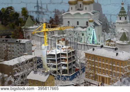 Miniature Construction Of A High-rise Building With A Tower Crane.
