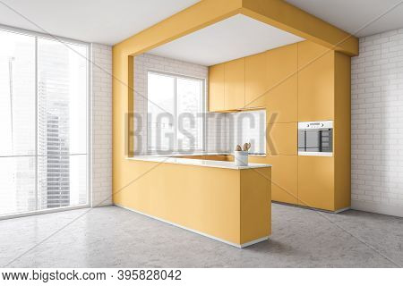Corner Of Modern Kitchen With White Walls, Concrete Floor And Yellow Cupboards. Window With Blurry C