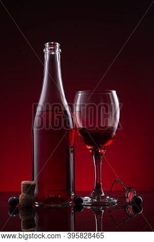 Bottle And Glass Of Lambrusco Wine  On Red Dark Background.