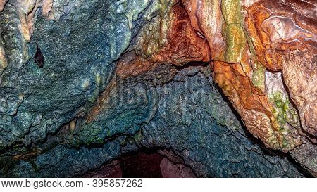 Close Up View Of Colorful Cave Roof And Dark Tunnel In The Background. One Bat Hanging. Vilinske Jam