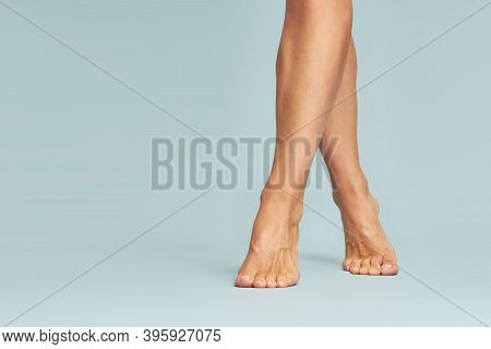 Perfect Depilation. Cropped Shot Of Beautiful Female Legs With Soft Silky Skin Over Blue Background