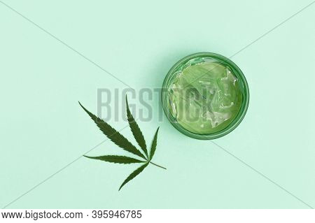 Jar With Transparent Cosmetic Product, Gel Or Cream With Cannabis Oil On Blue Colored Background. Fl