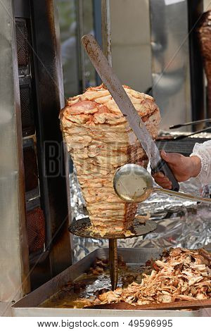 Doner kebab de pollo en su barbacoa especial con bandeja de carne en rodajas