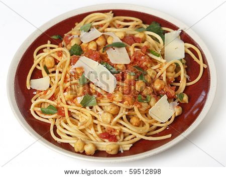 Spaghetti with a chickpea, tomato and chilli flakes sauce, garnished with fresh torn basil leaves and flakes of parmesan. This is a traditional Italian dish,called spaghetti alla ceci