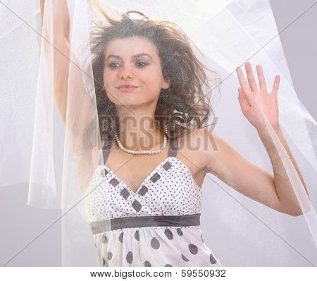 A fashionable woman standing with white material