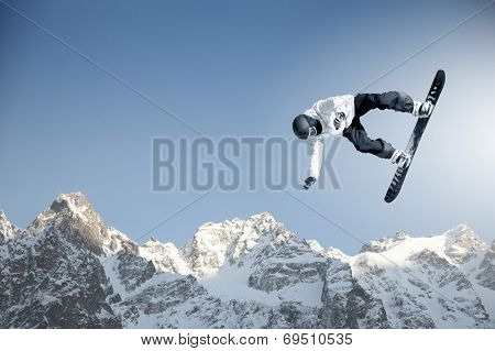 Snowboarder making high jump in clear blue sky