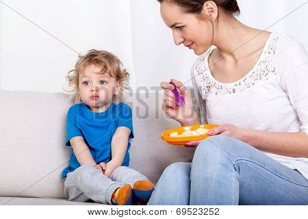 Mother Feeding Child On Couch