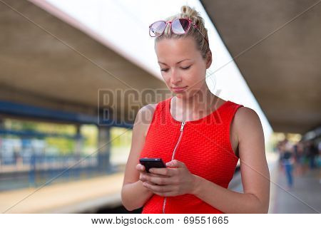 Young woman on platform of railway station.