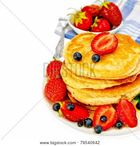 Flapjacks with strawberries and blueberries in bowl with napkin