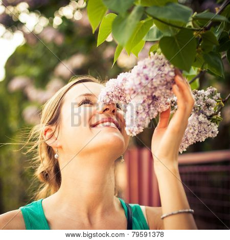 Beautiful young woman smelling white jasmin flowers