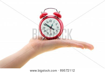 Red alarm clock on a woman's palm