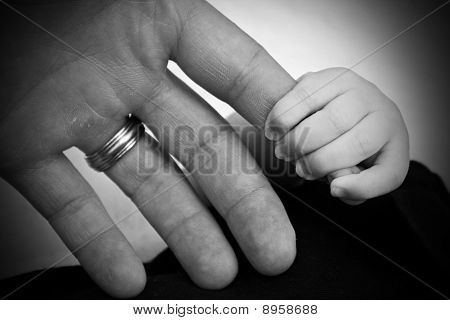 Dětská ruka svírající otce prst