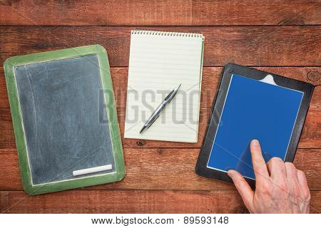 slate blackboard, with chalk, notepad with a pen and digital tablet with a finger - generations of making notes concept