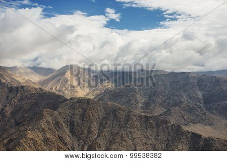 Aerial view of desert and high mountain from the airplane window. New Delhi-Leh flight ,India.