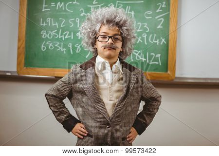 Portrait of little Einstein posing in front of chalkboard in a classroom