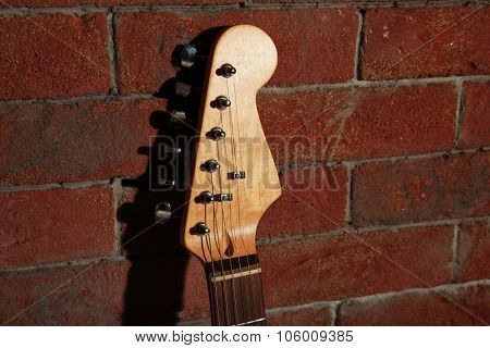 Guitar's fingerboard on brick wall background