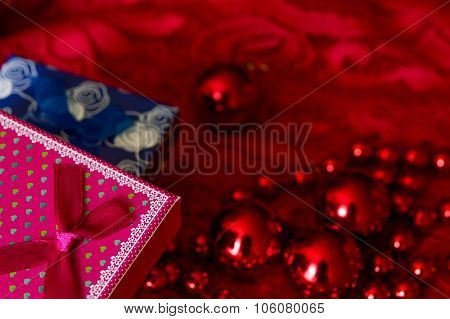 Christmas Gift And Garland Made From Small Red Beads.on A Red Background. New Year Toy.