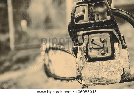Man sawing a log in his back yard with orange saw