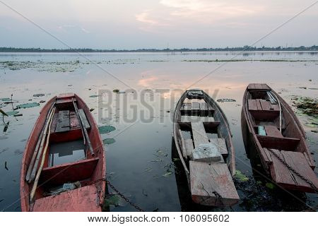 Moored Fishing Boats On Lake In Asia With Sunset Background