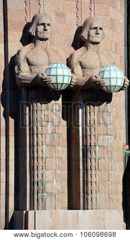 Statues holding the spherical lamps