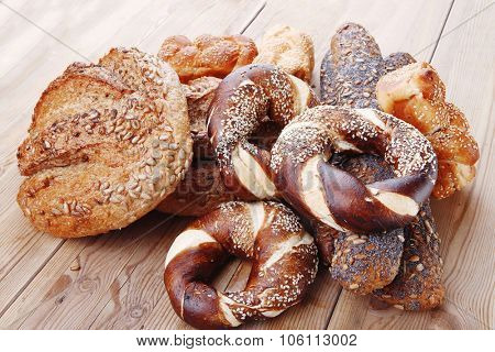 hot rural french round rye bread and baguette topped with sunflower seeds and sweet bagels on wooden tables