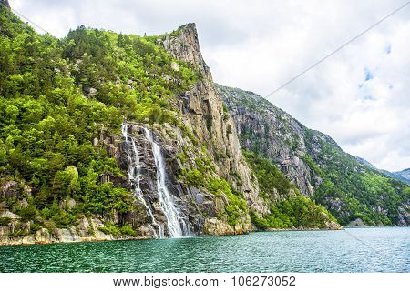 Famous Hengjanefossen waterfall coming down from a steep rock face into Lysefjord.