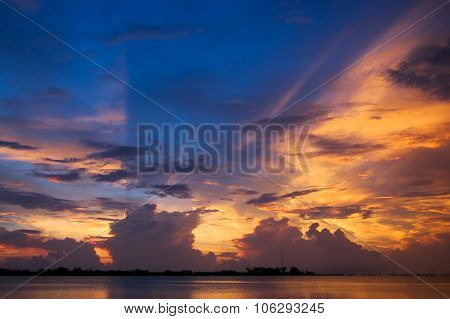 Sunset with clouds casting blue shadows across golden sky