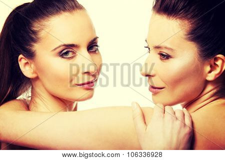 Two attractive sisters with make up embracing.