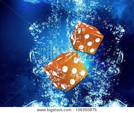 Conceptual image with dice cubes in clear blue water