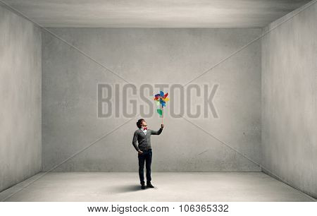 Young happy guy in casual with colorful windmill in hand
