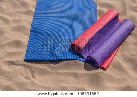 Yoga mats thrown on the beach - preparing for the lesson