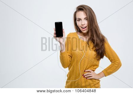 Portrait of a cheerful woman showing blank smartphone screen isolated on a white background