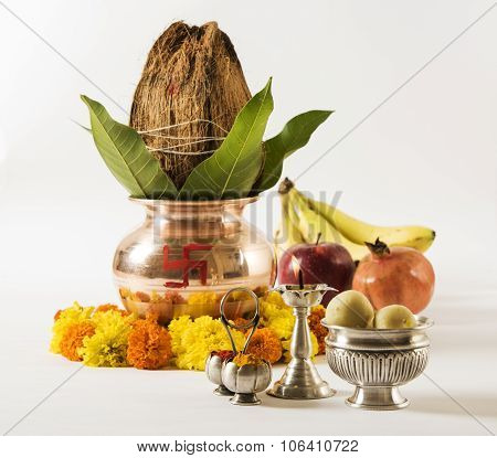 copper kalash with coconut and mango leaf with floral decoration, fruits, diya, sweet pedha,essentia