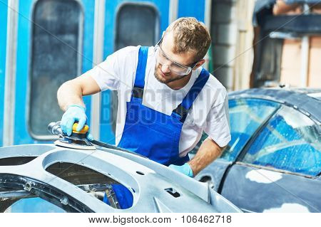auto mechanic worker polishing bumper car at automobile repair and renew service station shop by power buffer machine