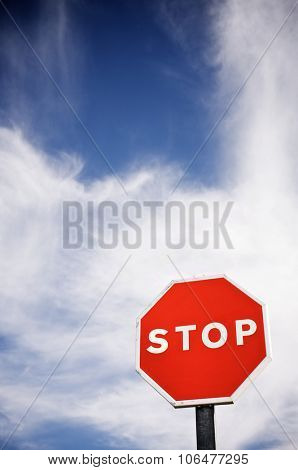 forefront of a stop sign with a cloudy sky