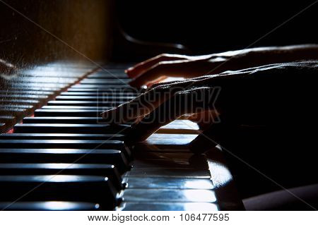 Woman's Hands On The Keyboard Of The Piano In Night Closeup