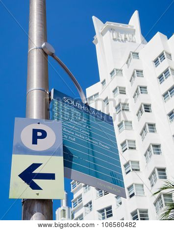 MIAMI,USA - AUGUST 8,2015 :  Street sign giving directions to Miami Beach landmarks with the famous Delano hotel on the background