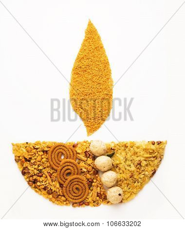 Traditional indian diwali snack or diwali food in diwali lamp form isolated on white. diwali greetin