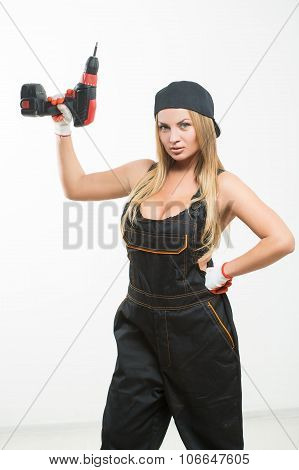 Young sexy female holding a cordless screwdriver