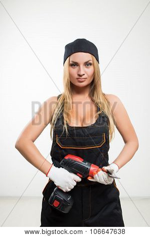 Young sexy female holding a cordless screwdriver
