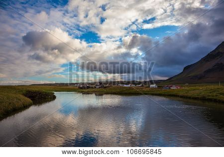 Quiet summer evening on the coast of Iceland. Small pond in the fishing settlement of Arnastapi