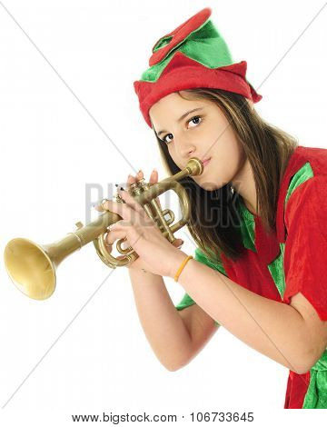 Half-length image of a pretty teen elf looking at the viewer as she tests a toy trumpet.  On a white background.