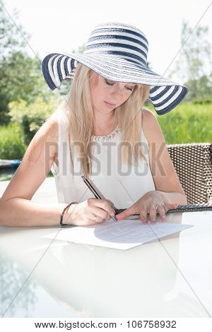 Young Beautiful Woman Is Writing On Sheed Of Paper
