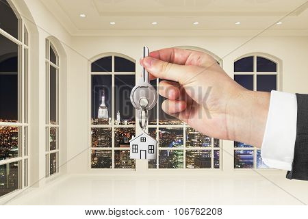 Man With Key In Hand In Modern White Empty Room With Night City View
