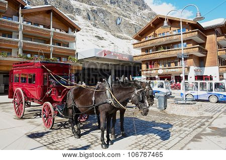 View to the horse carriage waiting for passengers in front of the Zermatt railway station.